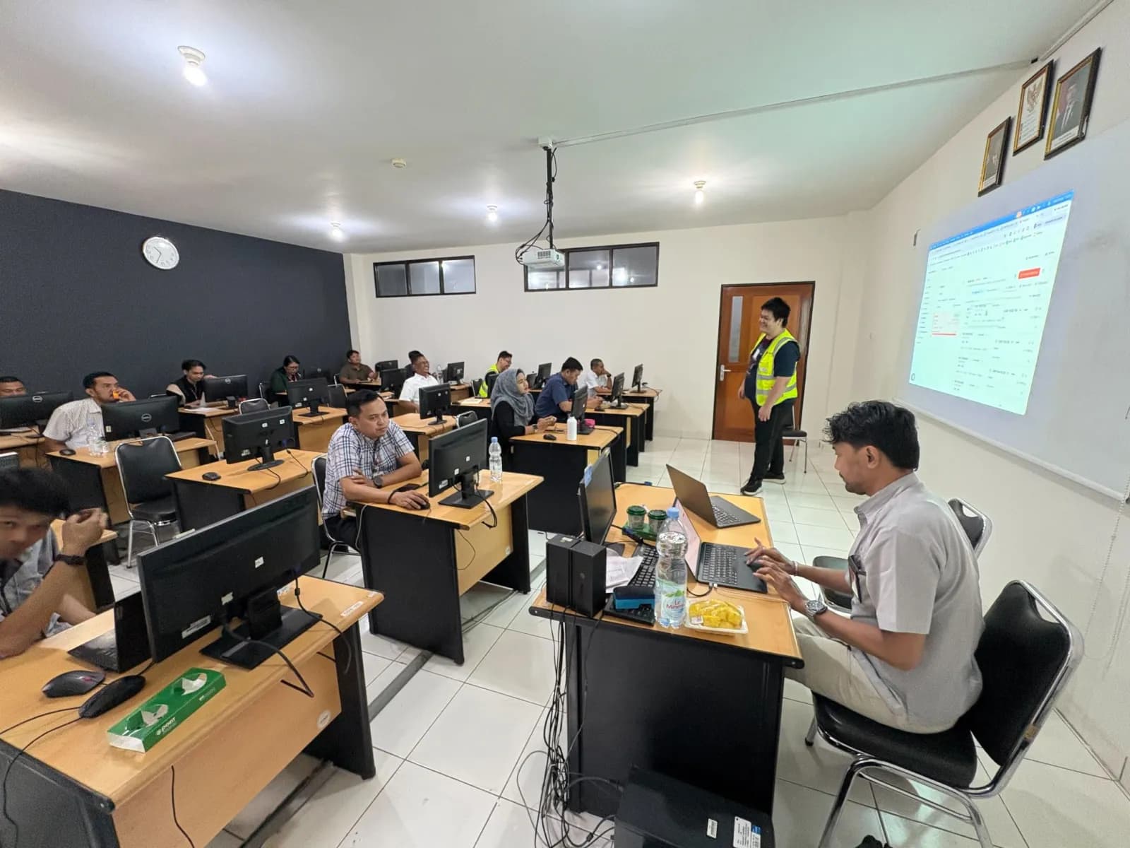 An associate running a training session for airline staff with the Belli app on the projector
