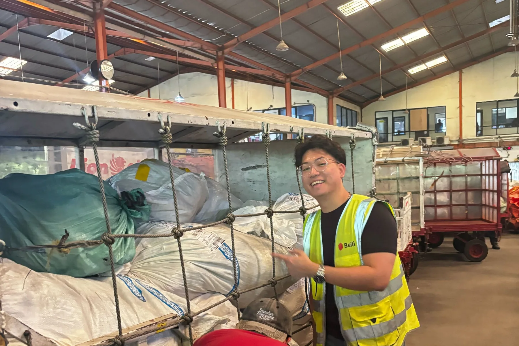A Belli team member beside a cargo cart in the Lion Parcel hall